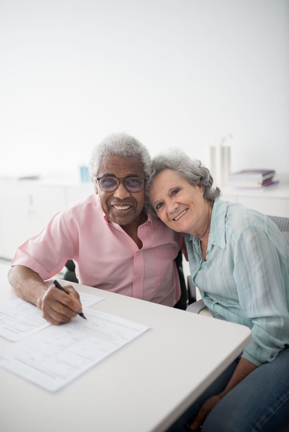 A couple reviewing financial documents with an advisor at a desk